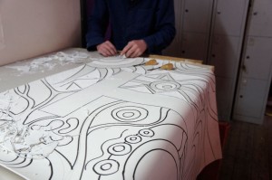 Artist cutting one of the lino tiles.