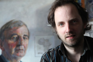 Artist Oisin Roche with his portrait of Niall Andrews in the back ground (Photo Liam Madden)