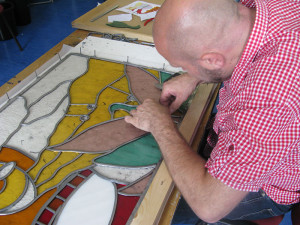 Working on a stained glass window.